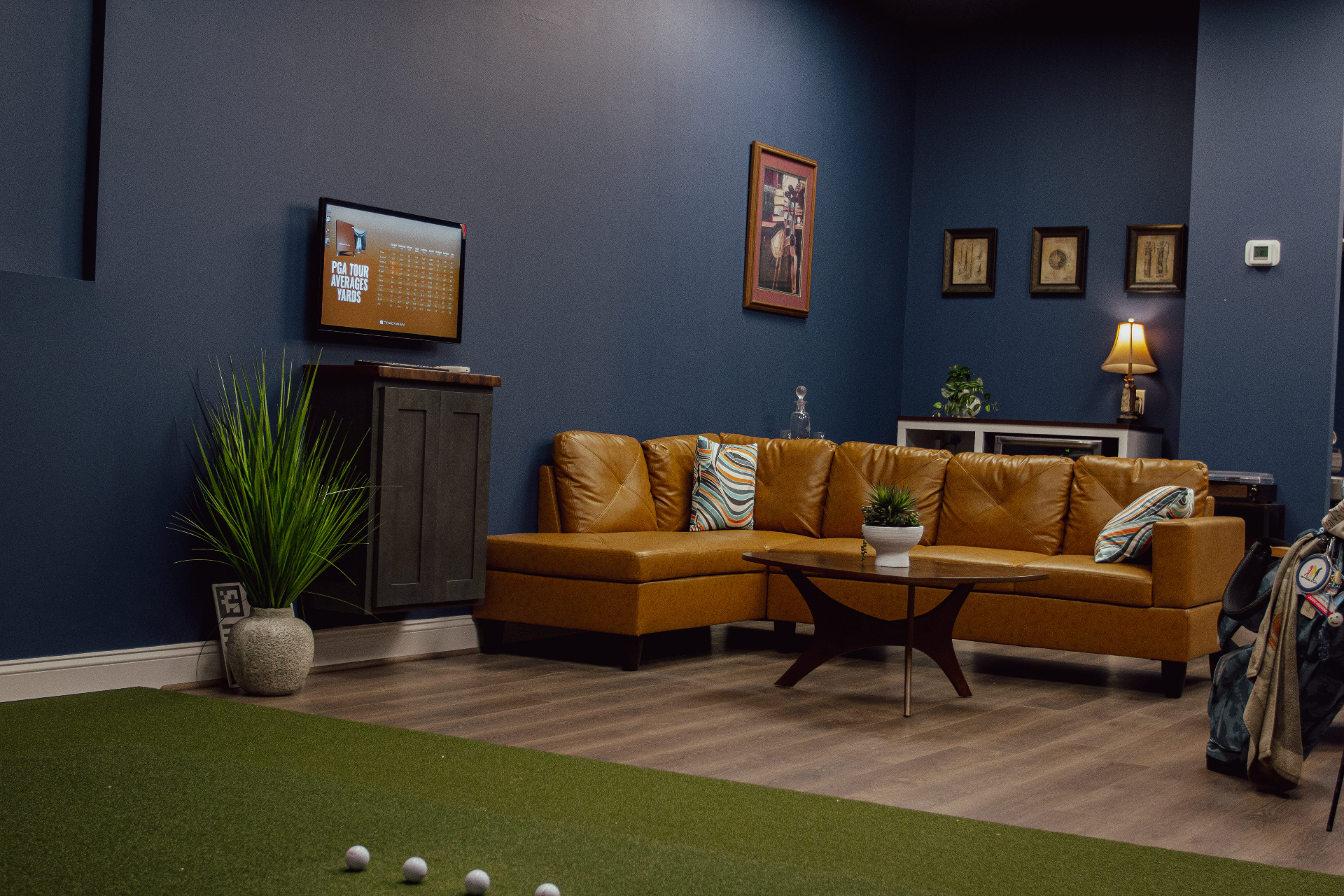 Franklin Golf Lab members' lounge with leather seating, TrackMan displays, and putting green